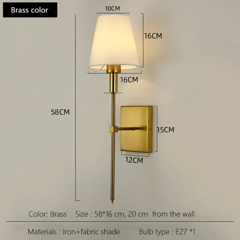 Black brass wall sconce with cylindrical fabric shade and iron frame ideal for bedroom lighting