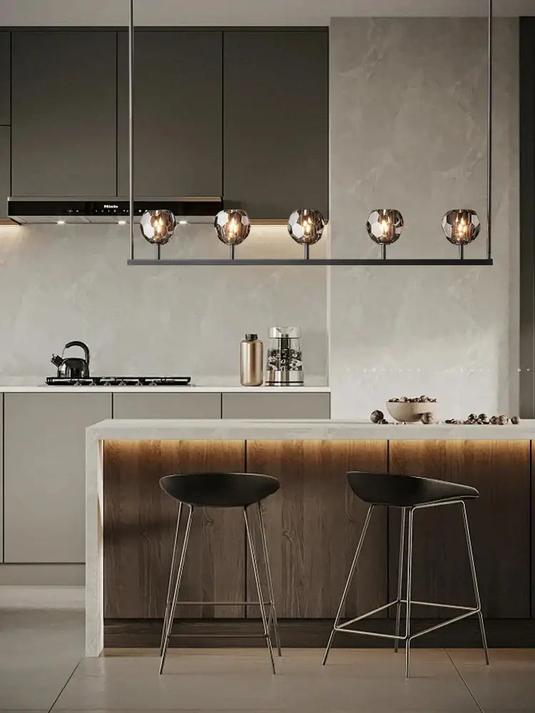 Modern black bar stools with slender metal legs complement decorbites black bronze copper chandelier lights at kitchen island