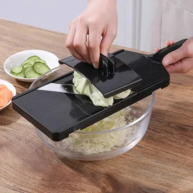 Black plastic decorbites cabbage grater with sharp blade and adjustable guard slicing cabbage into thin strips