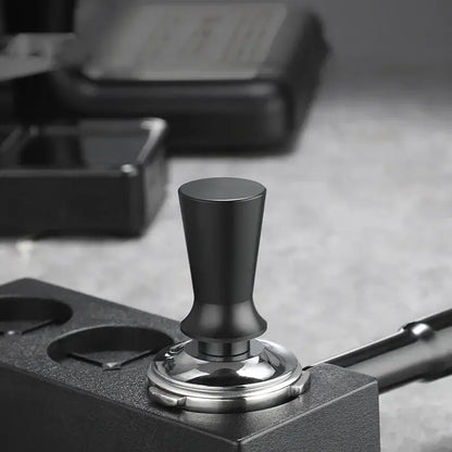 Black calibrated stainless steel espresso tamper set with black matte handle and polished silver base by decorbites