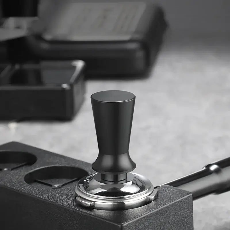 Black calibrated stainless steel espresso tamper set with black matte handle and polished silver base by decorbites