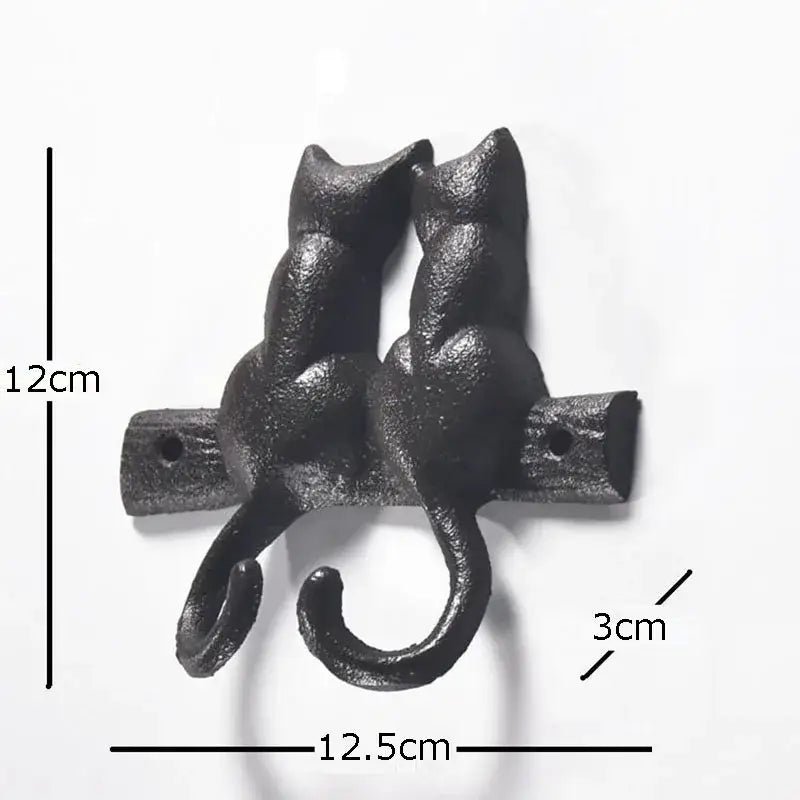 Black cast iron cat hook shaped like two cats with curved tails forming hooks for hanging shelf outdoor decorbites cat hook