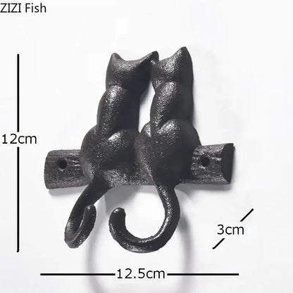 Black cast iron cat hook shaped like two cats with curved tails forming hooks for hanging shelf outdoor decorbites decor