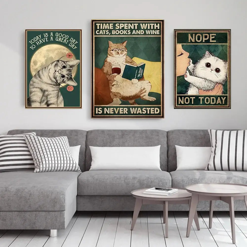 Three framed cat-themed posters featuring vintage black cat reading illustrations with humorous text above a gray sofa