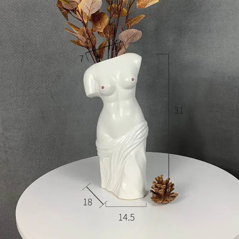 White ceramic human body figurine vase shaped like female torso with draped fabric and studded breasts decorbites