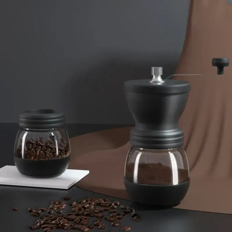 Black ceramic hand rocking coffee grinder with glass base and silver-toned handle for manual kitchen use