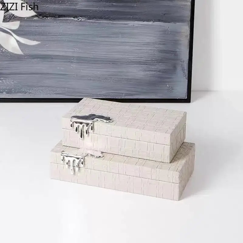 Two stacked off-white textured boxes with silver clasps in a black crocodile leather jewelry box storage case