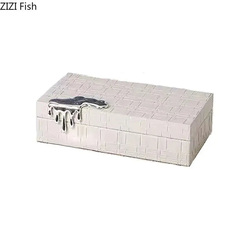 Silver jewelry box with black crocodile leather exterior and textured brick pattern featuring a dripping metal clasp