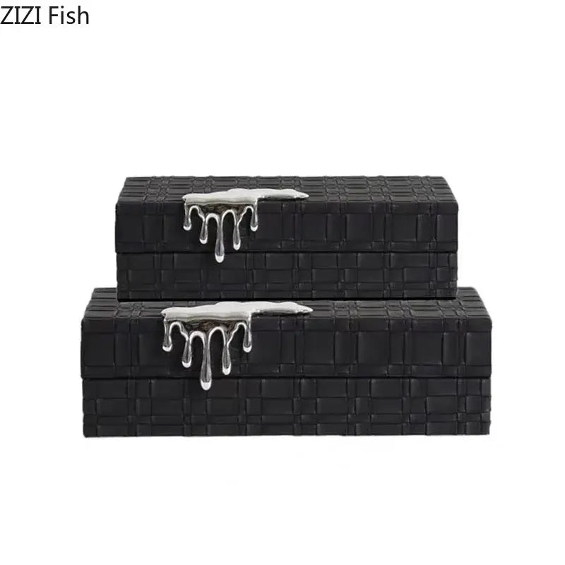 Black rectangular leather jewelry box with textured woven pattern and silver metallic drip accents on lids for storage