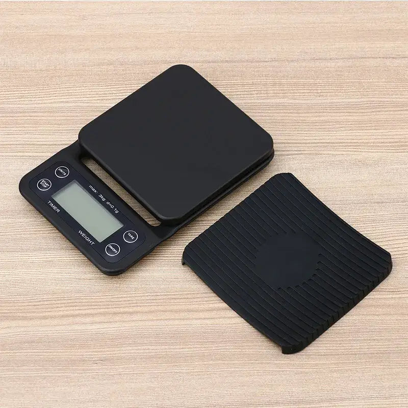 Black digital brewmaster coffee scale timer with sleek ribbed platform and matching silicone mat by decorbites