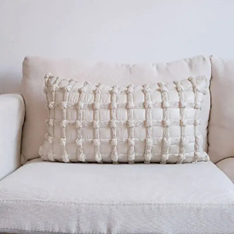 Cream-colored rectangular cushion cover with textured woven dot bubble pattern and raised tassels for home decor