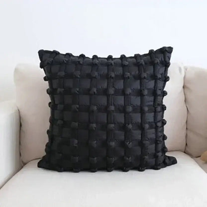 Black dot bubble quilted cushion cover with textured grid pattern and pom pom accents for stylish home decor
