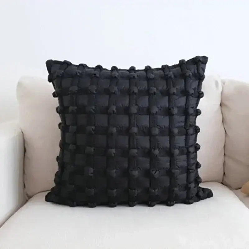 Black dot bubble quilted cushion cover with textured grid pattern and pom pom accents for stylish home decor