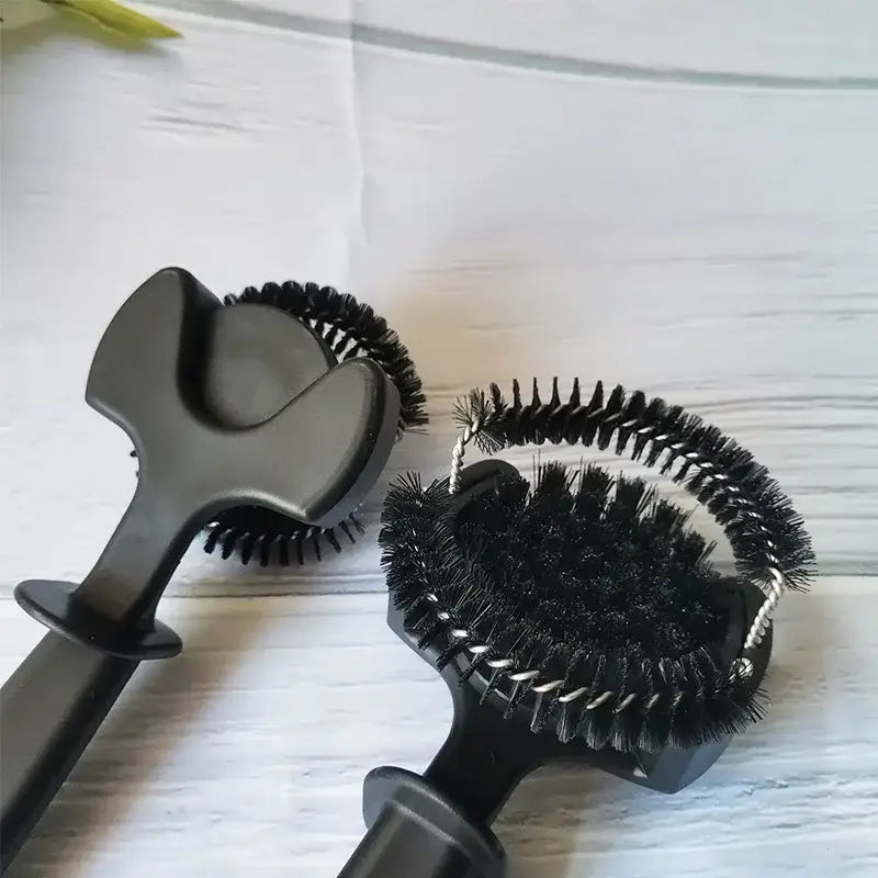 Black plastic-handled brush with dense black bristles and ergonomic design in brewing head cleaner set for espresso machines