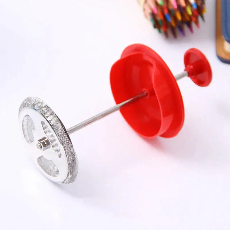 Red and silver pencil sharpener with textured metallic base and red plastic caps shown alongside a black glass 350ml french press