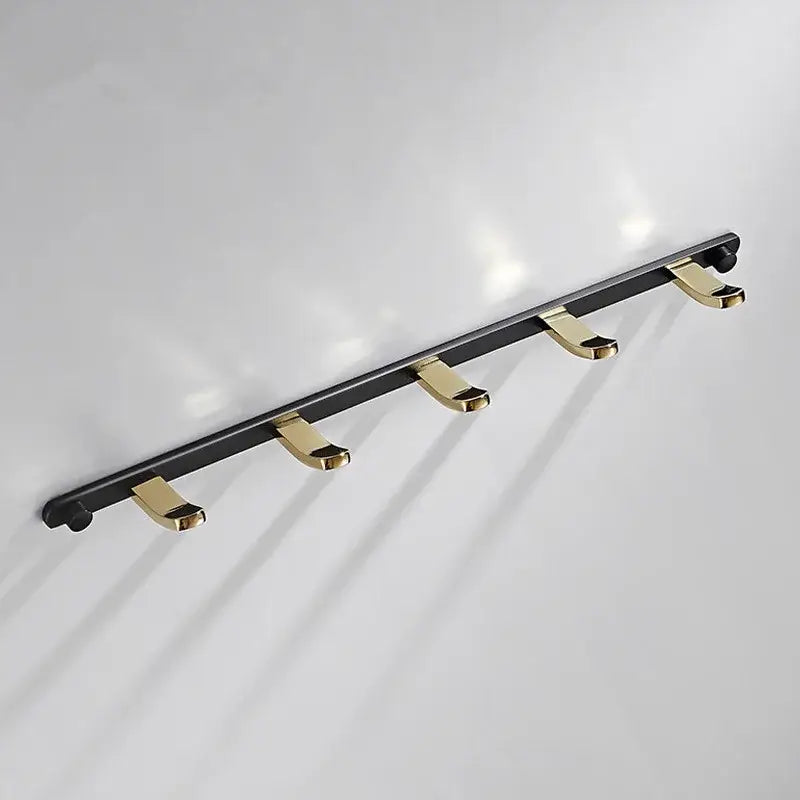 Black gold metal wall-mounted robe rack with four gold-toned decorbites brass hooks for towel storage