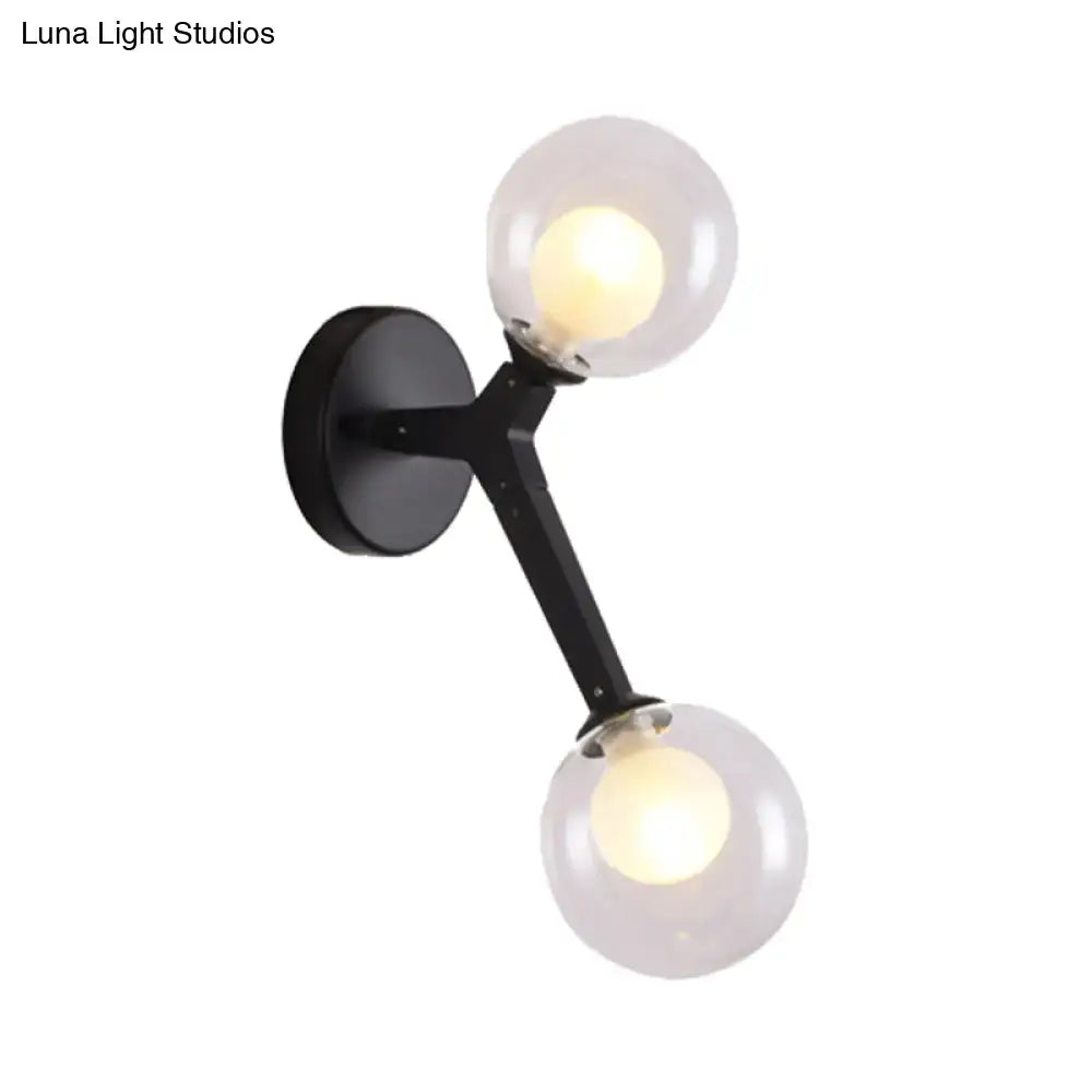 Black metal bubble wall sconce with two frosted glass globe shades for bedroom lighting with gold accents