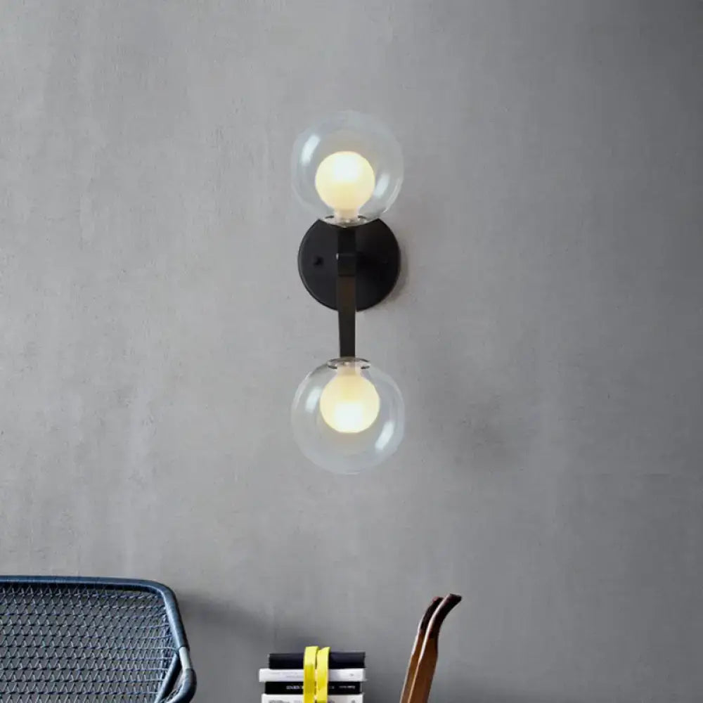 Modern black and gold bubble wall sconce with two clear glass globe shades for bedroom lighting