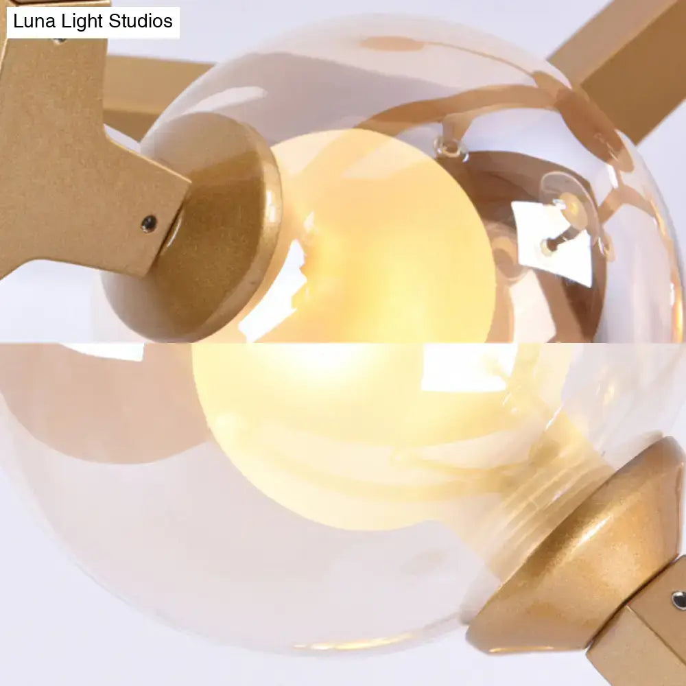 Black and gold bubble wall sconce with a gold-toned ceiling fan and clear glass globe housing for bedroom lighting