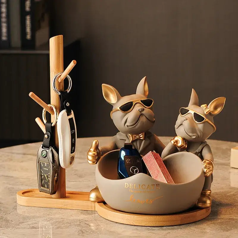 Gray and gold french bulldog butler statue with sunglasses and metallic accents serving as a stylish desk organizer