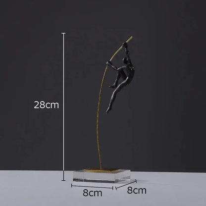 A sleek black metal decorbites gymnastic acrobat resin sculpture with a golden pole on a transparent base for living room decor