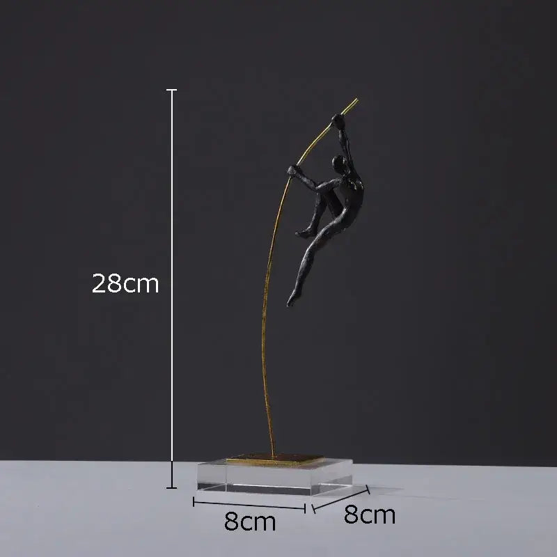 A sleek black metal decorbites gymnastic acrobat resin sculpture with a golden pole on a transparent base for living room decor