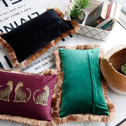 Three velvet throw pillow covers in black emerald green and burgundy with gold leopard print and tassel fringe edges