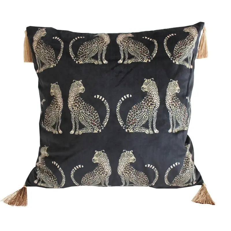 Black velvet throw pillow cover with cream and brown leopard print pattern and natural tassels at each corner