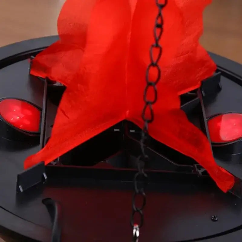 Red translucent plastic star decoration hanging from black chain on black hanging electronic brazier flame pendant light