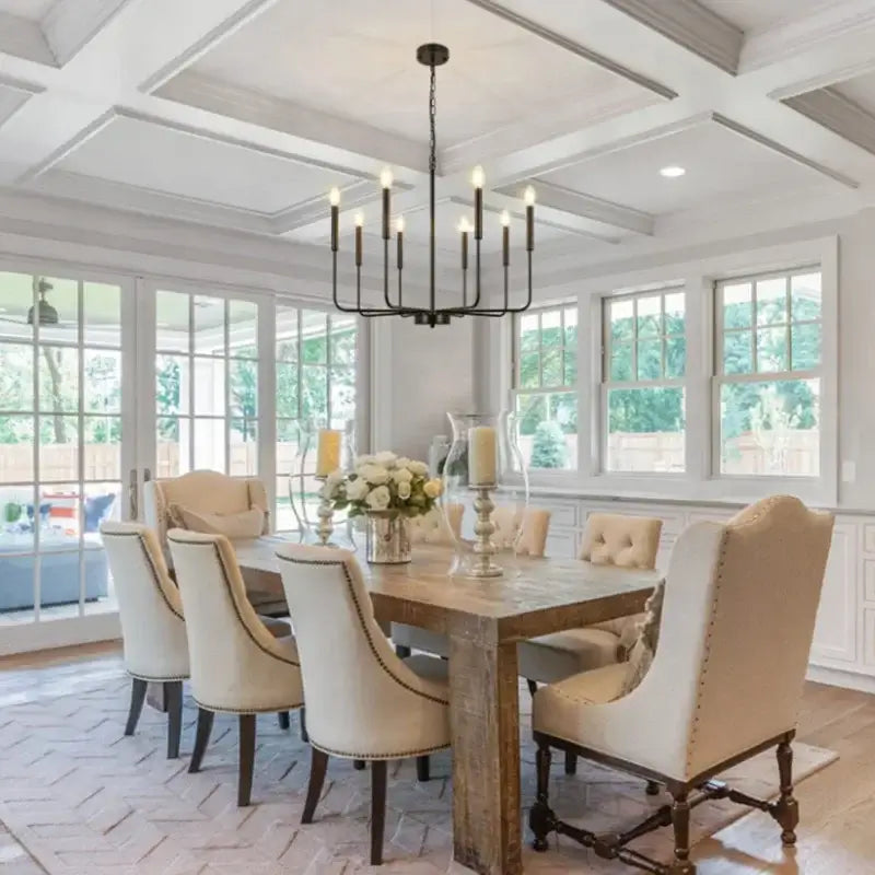 A rustic wooden dining table with cream upholstered chairs under a black iron branch chandelier pendant light decorbites iron branch
