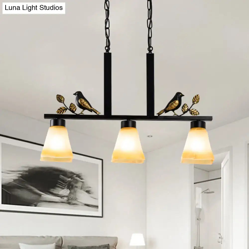 DecorBites black metal island light pendant with gold bird accents and three warm tan glass shades for dining room