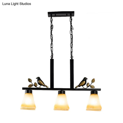 DecorBites black island light pendant with ornate bird and leaf accents and three tan glass shades for dining room