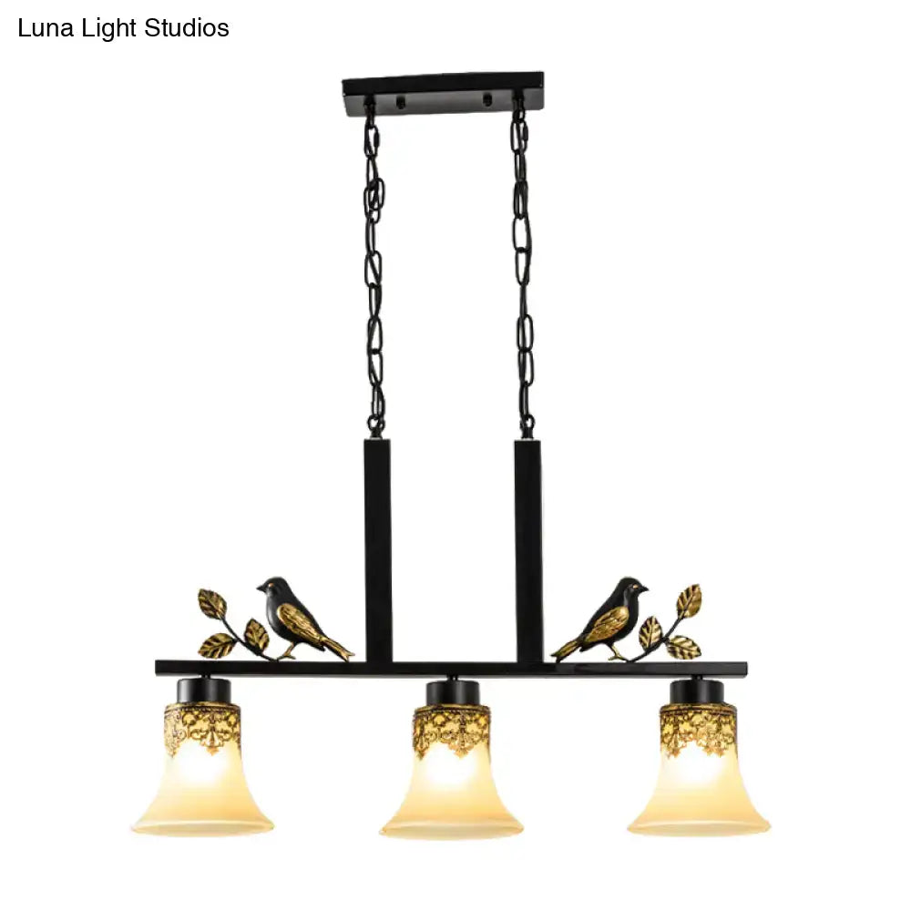 DecorBites black wrought iron island light pendant with gold bird motifs and three tan glass shades for dining room