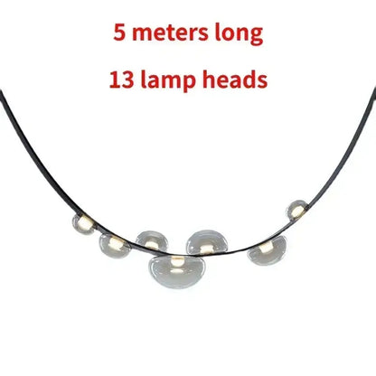 Black leather and glass pendant light features 13 dome-shaped light sources on a 5-meter cord as a dining room focal point
