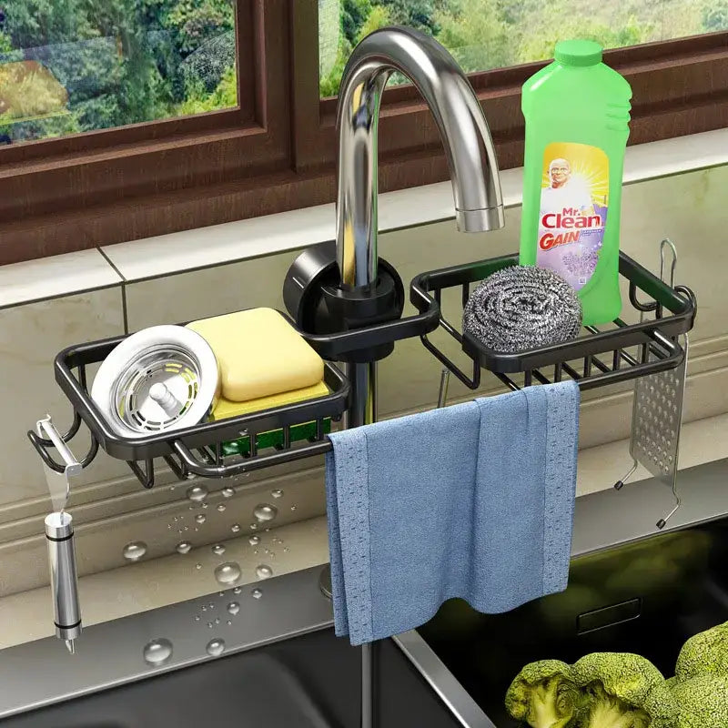 Black metal adjustable kitchen sink rack by decorbites with multiple compartments holding sponge scrubber and towel