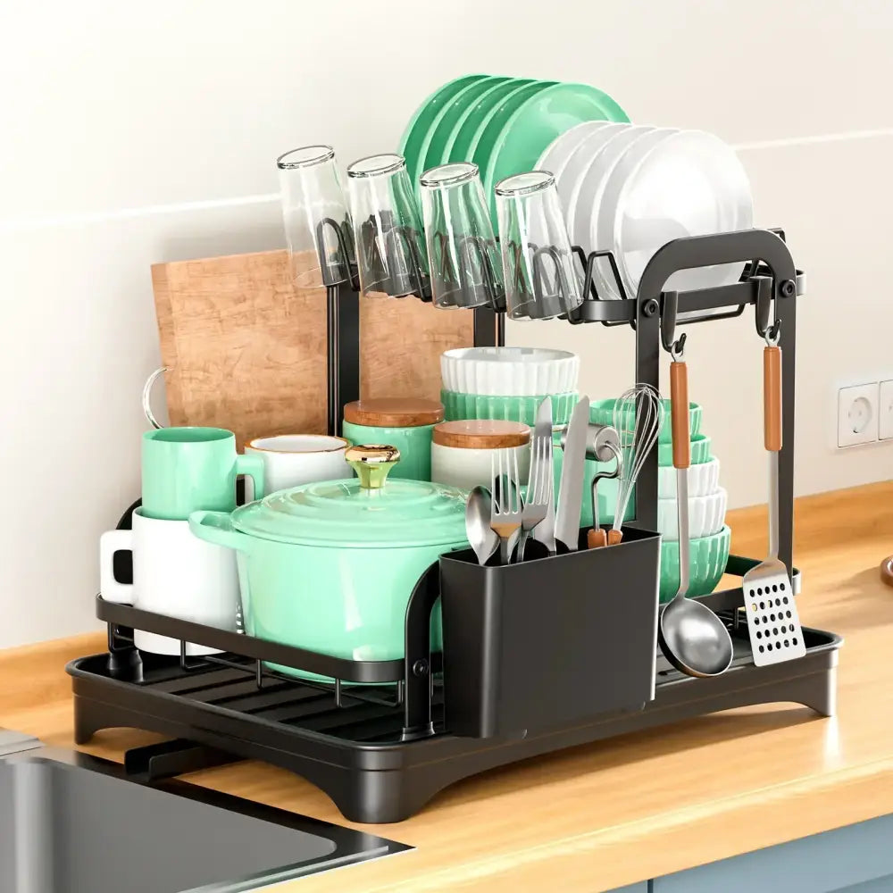 Black metal double layer dish drying rack with multiple tiers holding green and white dishes glassware and utensils