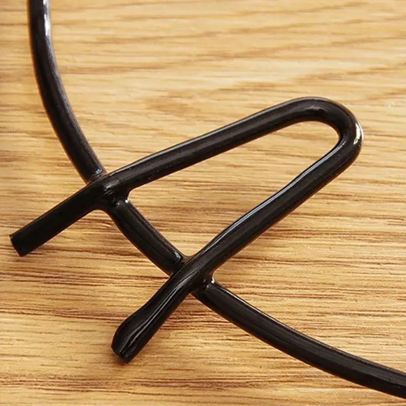 Black glossy metal wire pot holder with sleek curved design for decorbites gas stove burner rack use