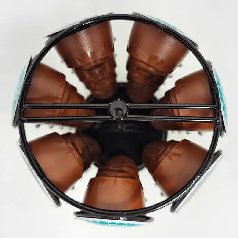 Black metal rotating dolce gusto storage rack holding multiple brown coffee capsules in a circular design