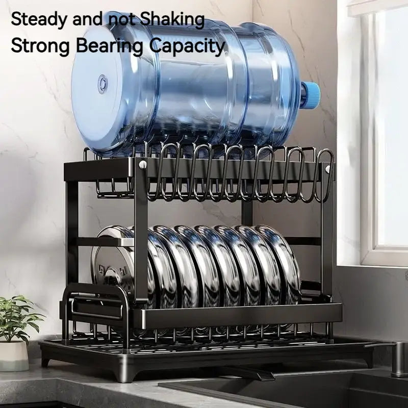 Black metal two-tier kitchen dish drainer with curved wire shelves holding plates and a blue water bottle decorbites kitchen dish