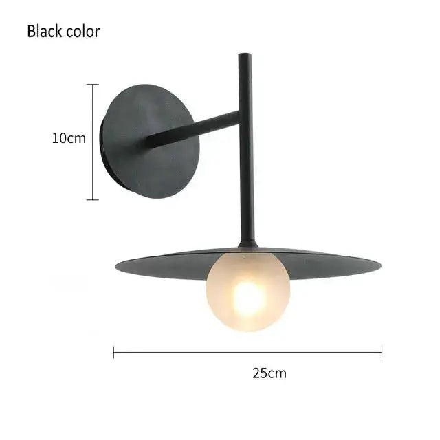 Black minimalist glass ball wall lamp with matte finish, circular base, and wide disc shade for bedroom sconce decorbites