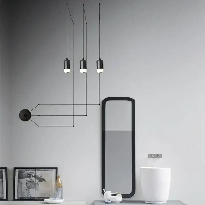 Three black minimalist led pendant lights hanging by cords emitting a soft glow for bedroom wall lamp decorbites