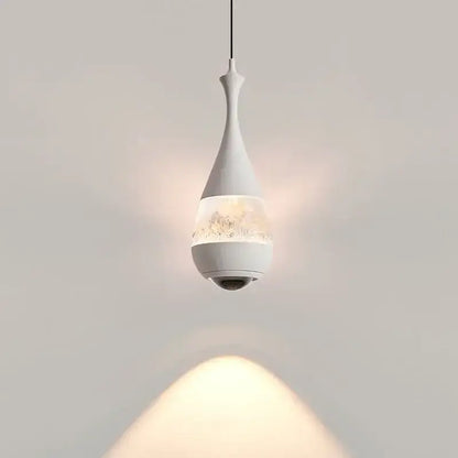 A sleek white glass pendant chandelier with teardrop shape and discreet camera for dining room decor
