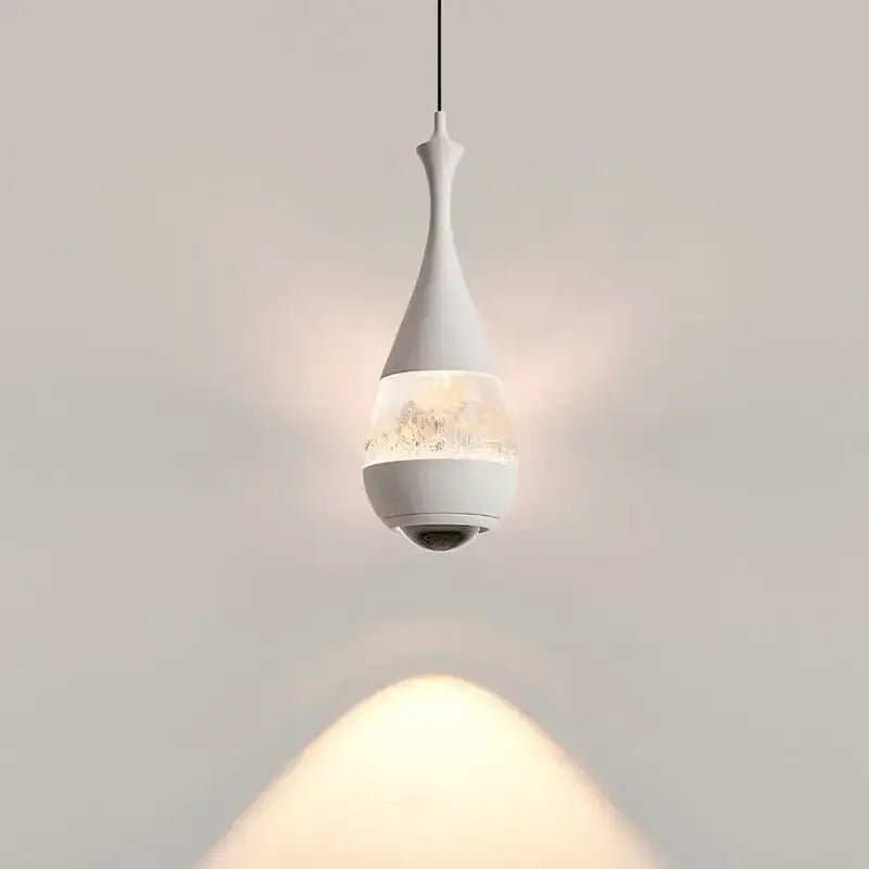 A sleek white glass pendant chandelier with teardrop shape and discreet camera for dining room decor