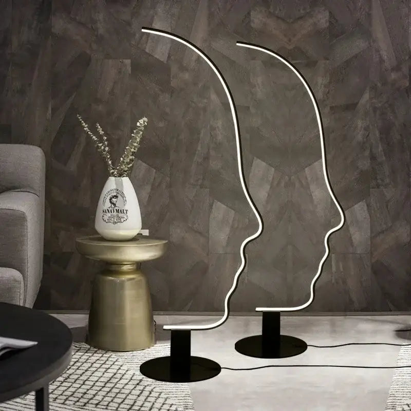 Two sleek black nordic human face floor lamps with glowing white neon outlines for modern living room decorbites decor