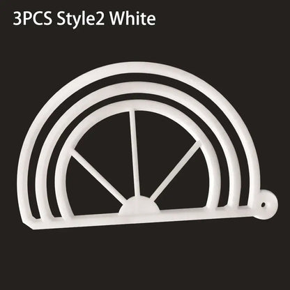 White plastic cookie cutter shaped like half circle with spokes designed for circular cookies alongside black decorbites hat brim bender