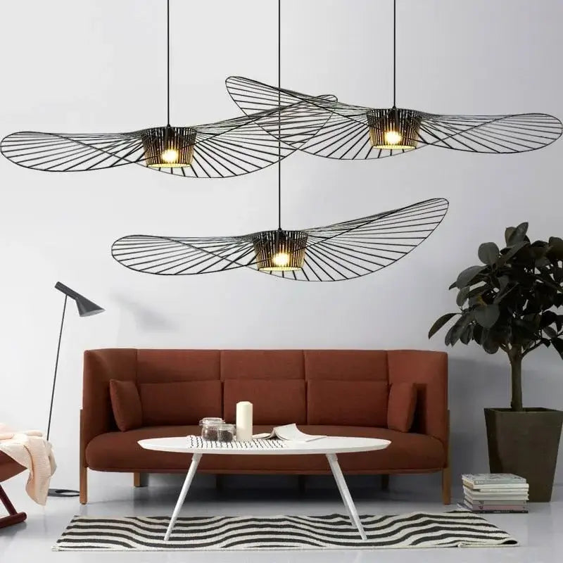Three black rattan hat led chandelier pendant lights with warm interiors hang above a modern living room decorbites black rattan