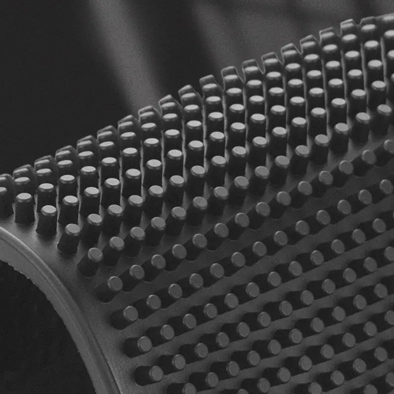 Black silicone bath brush with dense rounded bristles arranged in a curved pattern for decorbites coffee bar cup mats