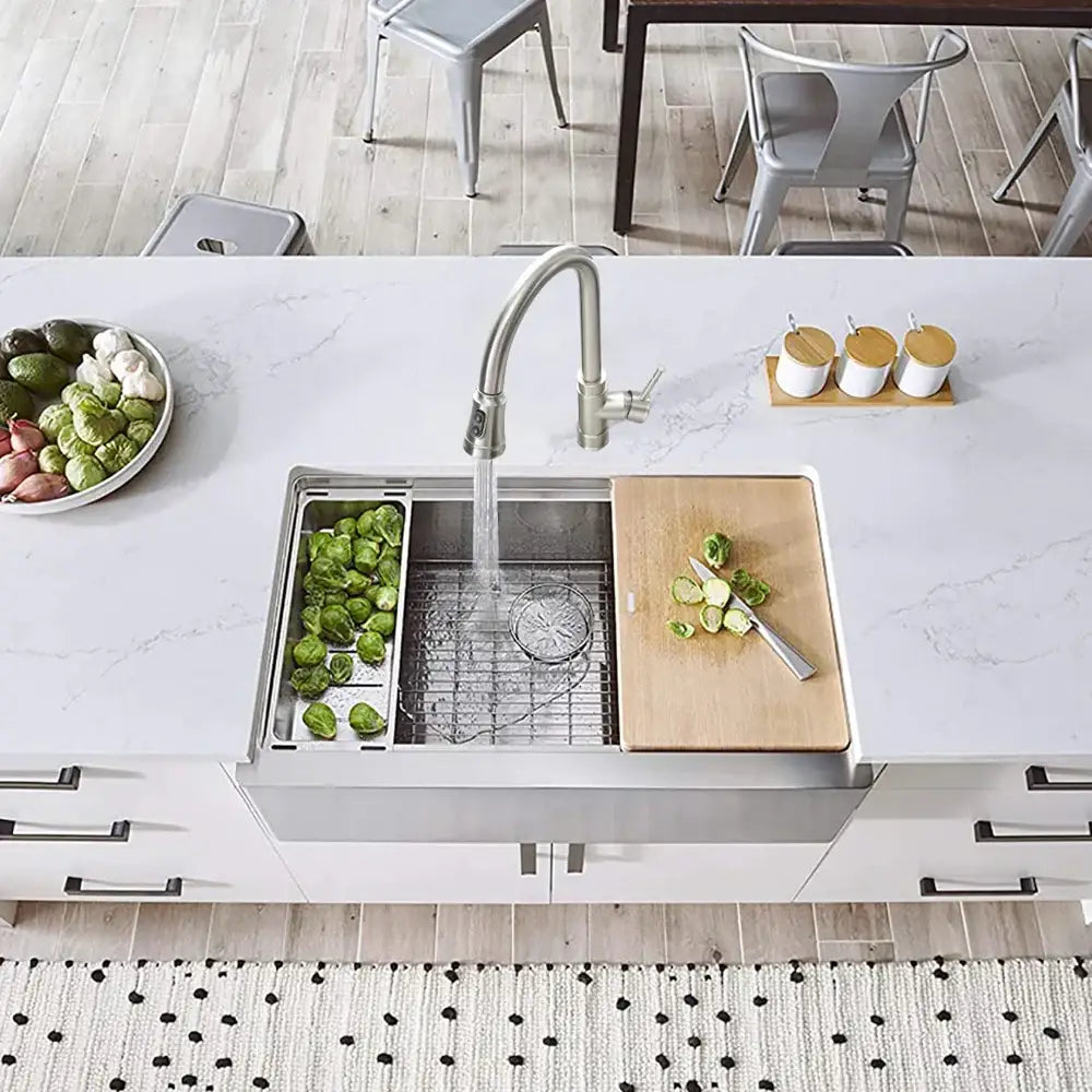 Black single handle pull out kitchen faucet with swivel spout installed on stainless steel farmhouse sink with divided compartments