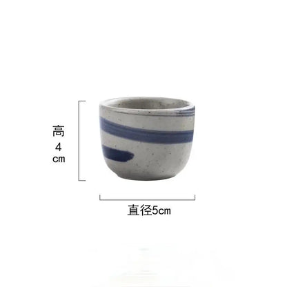 A small handcrafted ceramic wine sake cup with speckled gray glaze and blue stripes in decorbites ceramic wine set