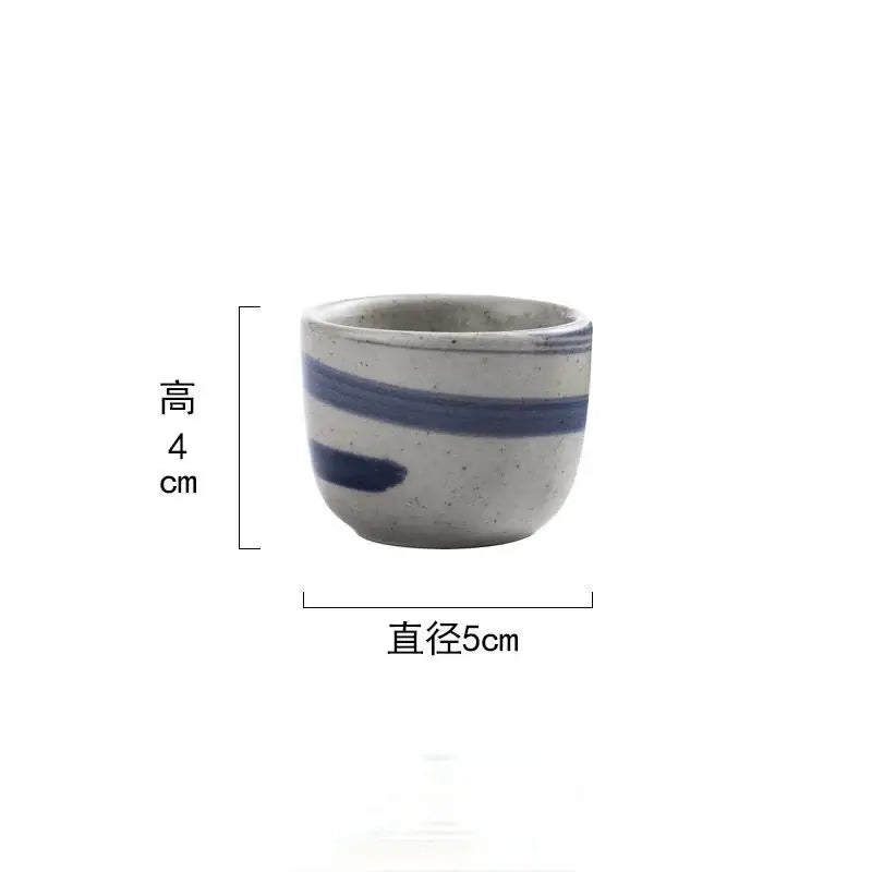 A small handcrafted ceramic wine sake cup with speckled gray glaze and blue stripes in decorbites ceramic wine set